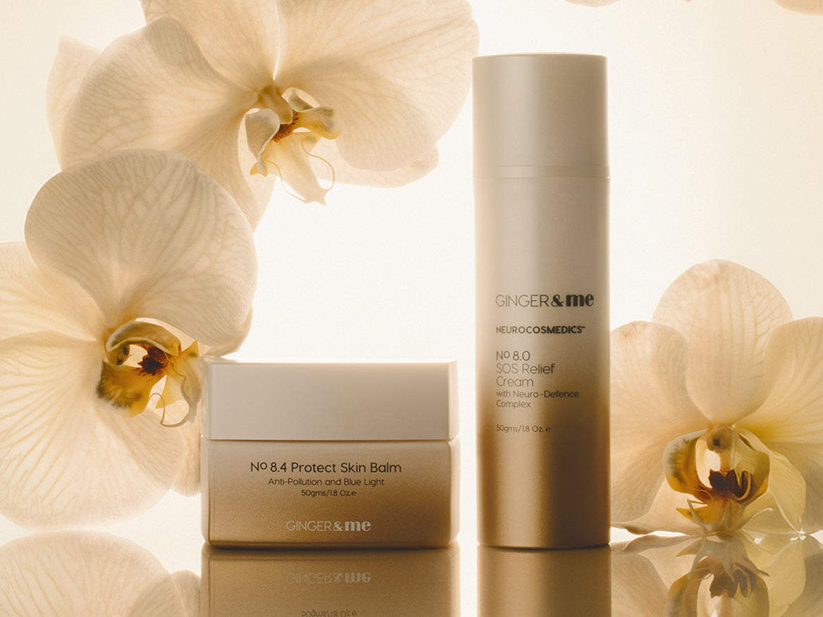 GINGER&ME No 8.4 Protect Skin Balm and No 8.0 SOS Relief Cream styled with white orchids on a cream background.